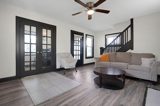 living area featuring ceiling fan, french doors, stairs, baseboards, and wood finished floors