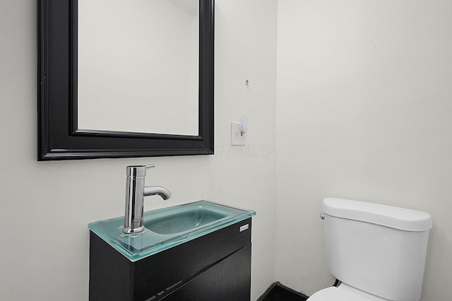 half bathroom featuring vanity and toilet