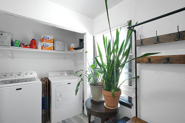 laundry area featuring separate washer and dryer, laundry area, and light wood-style flooring