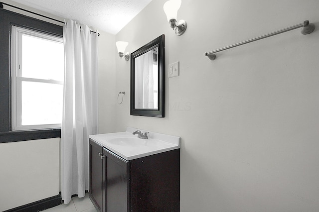 bathroom with a textured ceiling, tile patterned floors, and vanity