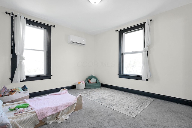 bedroom featuring carpet flooring, an AC wall unit, and baseboards