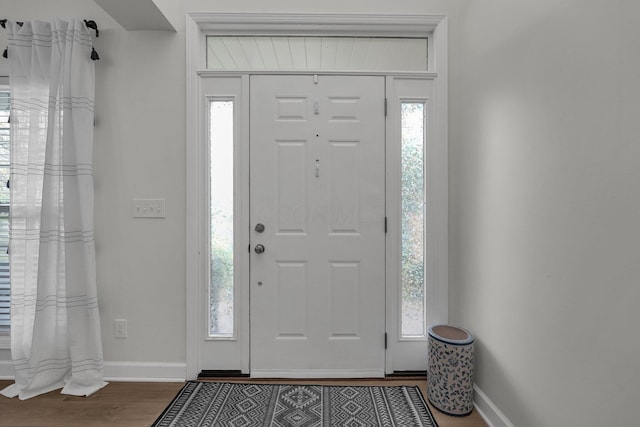 foyer entrance featuring baseboards and dark wood finished floors