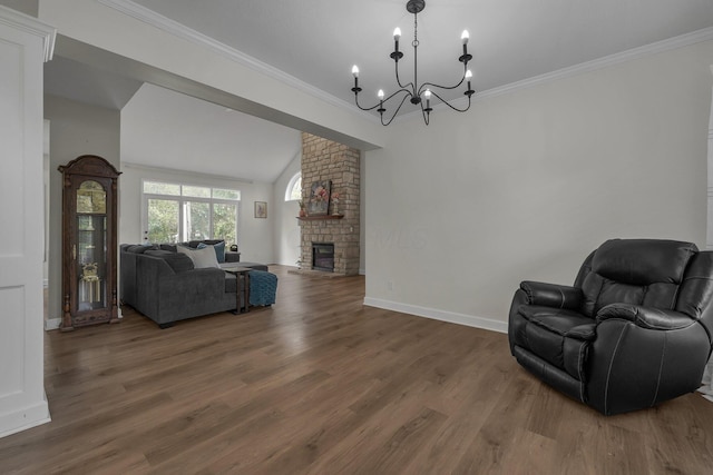 living room with wood finished floors, a notable chandelier, baseboards, a large fireplace, and vaulted ceiling