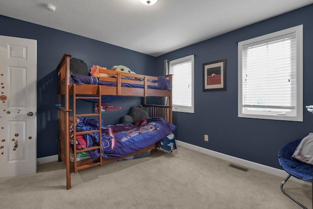 carpeted bedroom featuring baseboards and visible vents
