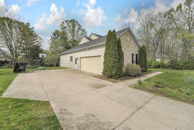 view of side of property featuring concrete driveway, an attached garage, stone siding, and a lawn