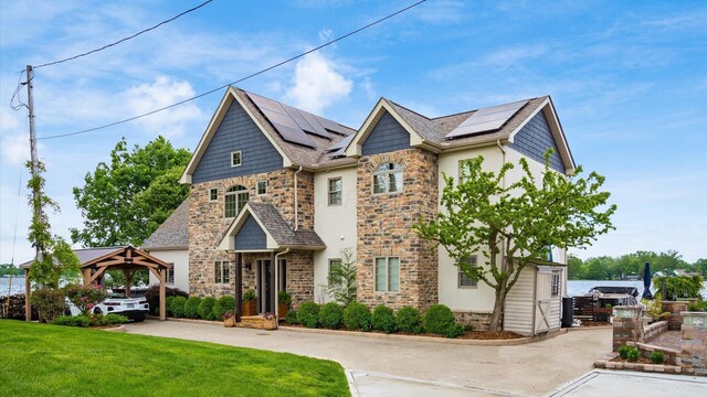 11290 Honeycreek Rd NW, Thornville, OH 43076 - view of front of house with stone siding, a gazebo, roof mounted solar panels, a front yard, and stucco siding