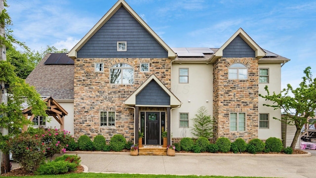 11290 Honeycreek Rd NW, Thornville, OH 43076 - view of front of house featuring stone siding, roof mounted solar panels, and stucco siding