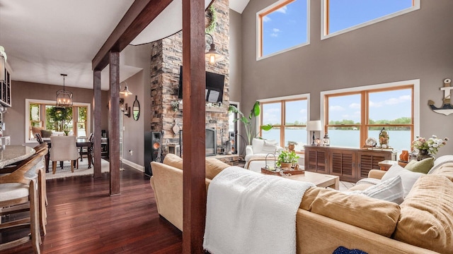 11290 Honeycreek Rd NW, Thornville, OH 43076 - living area with a chandelier, a stone fireplace, dark wood-style floors, plenty of natural light, and a towering ceiling