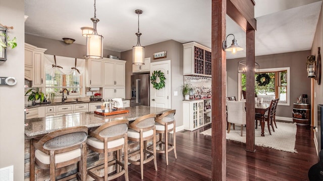 11290 Honeycreek Rd NW, Thornville, OH 43076 - kitchen featuring high quality fridge, dark wood-style flooring, baseboards, a breakfast bar area, and a sink