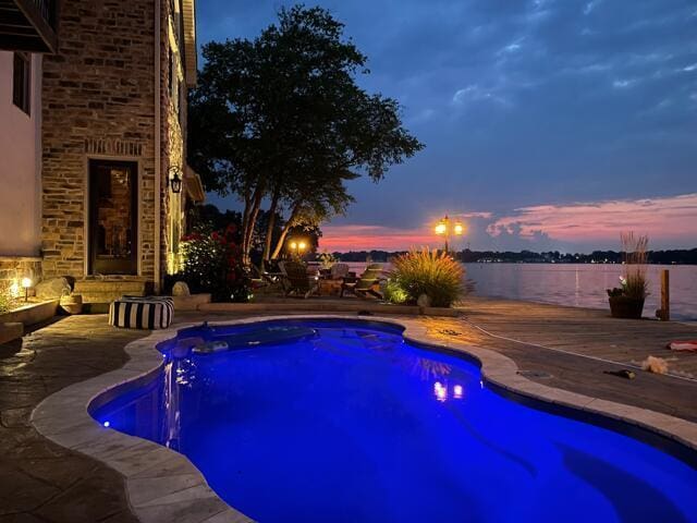 11290 Honeycreek Rd NW, Thornville, OH 43076 - pool at dusk featuring an outdoor pool, a patio area, and a water view