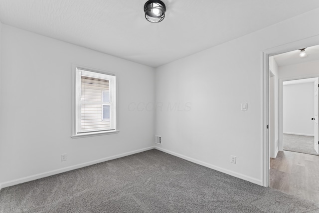 carpeted empty room with baseboards and visible vents