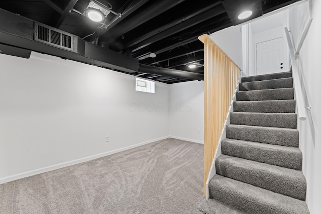 below grade area featuring baseboards, stairs, visible vents, and carpet floors