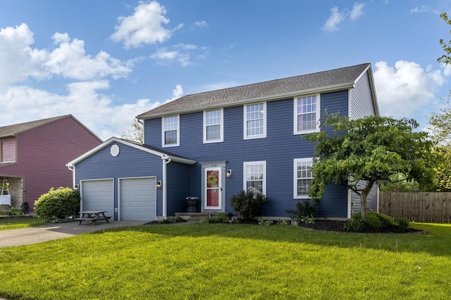 colonial-style house featuring a garage, fence, driveway, and a front yard