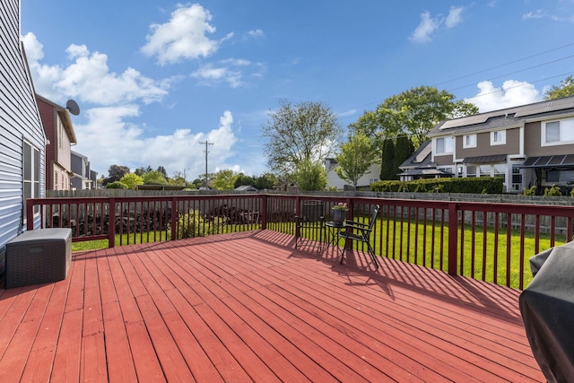wooden deck with a yard and a fenced backyard