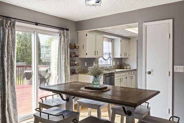 dining area with a textured ceiling and plenty of natural light