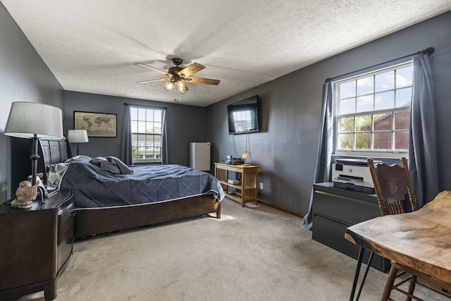 bedroom with a ceiling fan, a textured ceiling, and light colored carpet