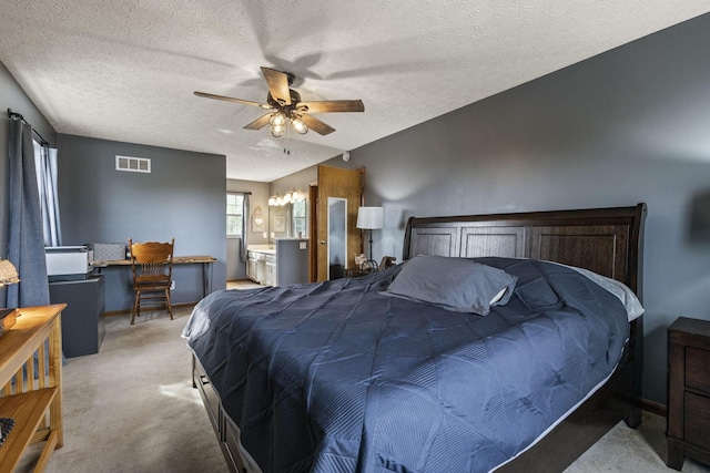 carpeted bedroom with a ceiling fan, a textured ceiling, visible vents, and ensuite bath
