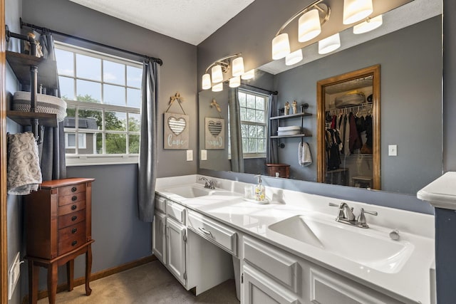 bathroom featuring a sink, plenty of natural light, and double vanity