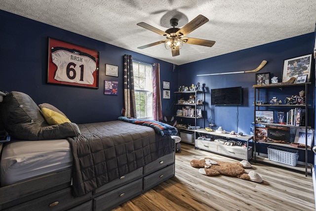 bedroom featuring a ceiling fan, a textured ceiling, and wood finished floors