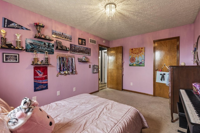 bedroom with a textured ceiling, visible vents, light carpet, and baseboards