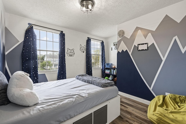 bedroom featuring baseboards, a textured ceiling, and dark wood-type flooring