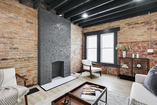 1010 Bruck St, Columbus, OH 43206 - living area with a brick fireplace, beam ceiling, wood finished floors, and brick wall