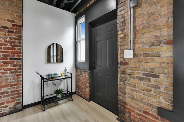 1010 Bruck St, Columbus, OH 43206 - entryway featuring brick wall, baseboards, and wood finished floors