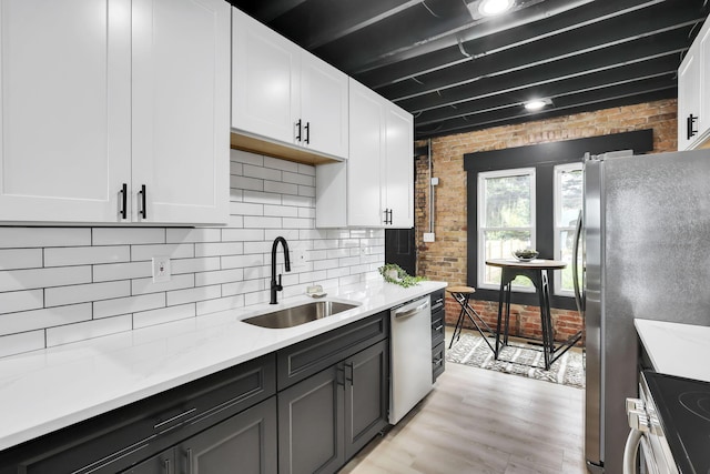 1010 Bruck St, Columbus, OH 43206 - kitchen with a sink, white cabinets, appliances with stainless steel finishes, and brick wall