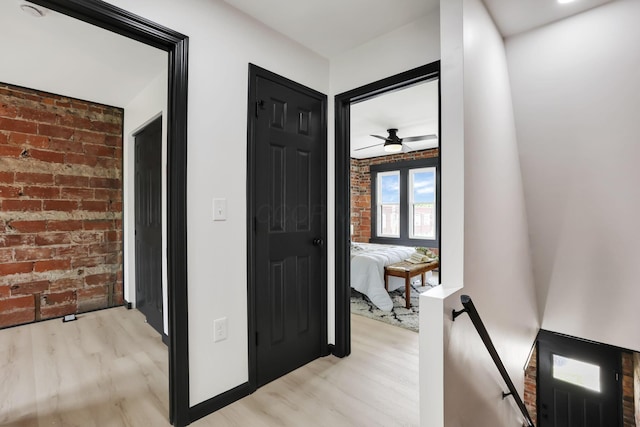 1010 Bruck St, Columbus, OH 43206 - hallway with brick wall, an upstairs landing, and light wood-style flooring