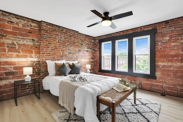 1010 Bruck St, Columbus, OH 43206 - bedroom featuring brick wall and wood finished floors