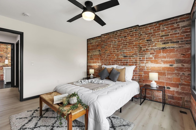 1010 Bruck St, Columbus, OH 43206 - bedroom with light wood-type flooring, a ceiling fan, and brick wall