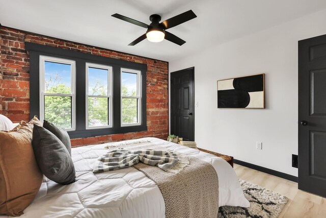 1010 Bruck St, Columbus, OH 43206 - bedroom featuring baseboards, a ceiling fan, light wood-style flooring, and brick wall