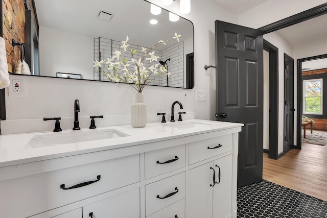 1010 Bruck St, Columbus, OH 43206 - full bath featuring a sink, wood finished floors, double vanity, and visible vents