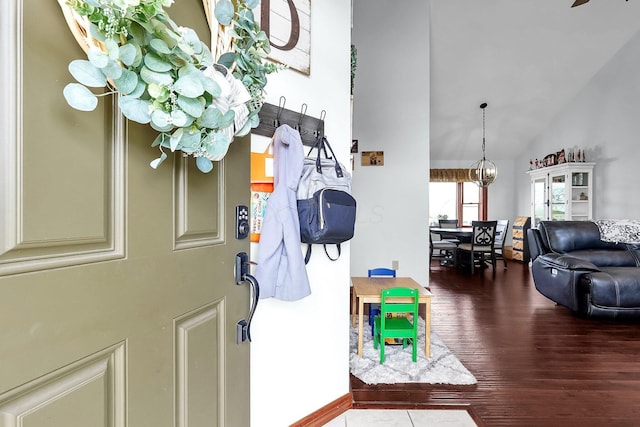 entrance foyer with baseboards, high vaulted ceiling, and wood finished floors