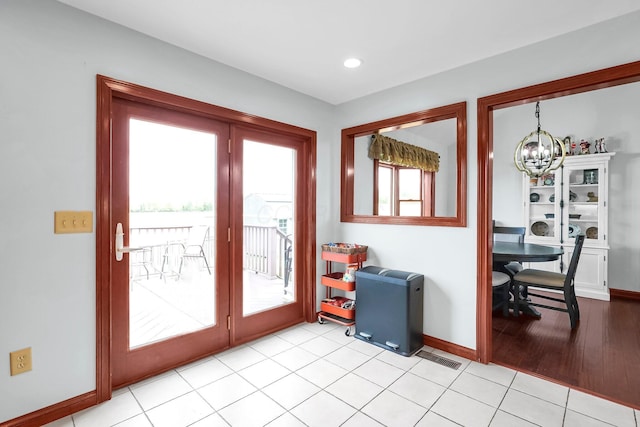 doorway to outside featuring baseboards, recessed lighting, a chandelier, and visible vents