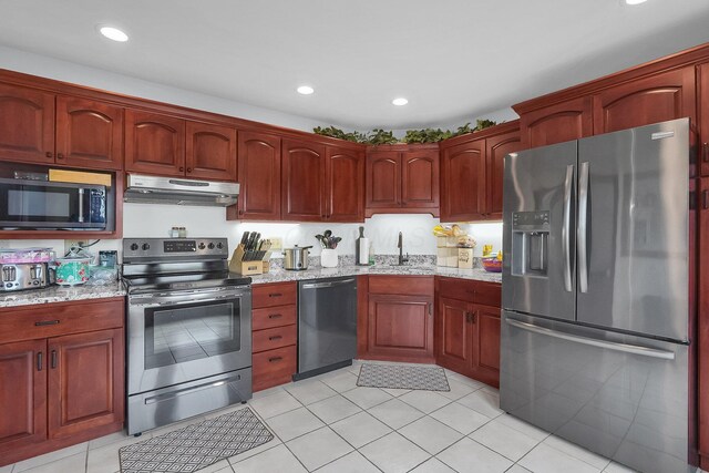 1574 Brooke Park Dr, Circleville, OH 43113 - kitchen with under cabinet range hood, stainless steel appliances, a sink, and light stone counters