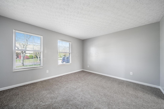 unfurnished room with carpet flooring, a textured ceiling, and baseboards