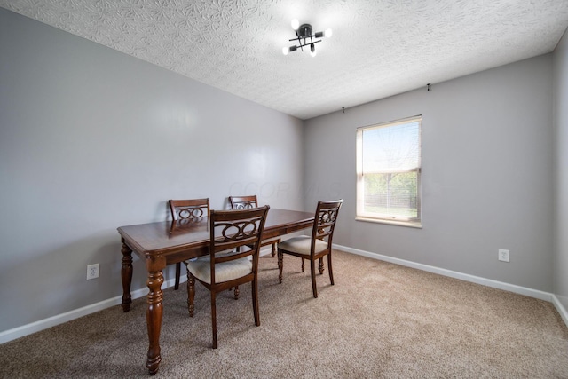 office area with a textured ceiling, light colored carpet, and baseboards