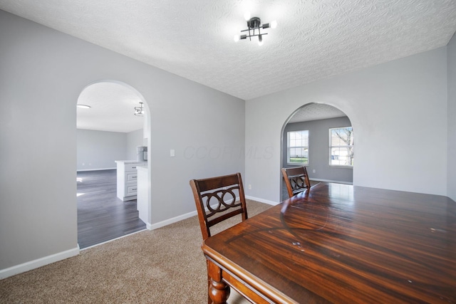 dining area with arched walkways, baseboards, and carpet