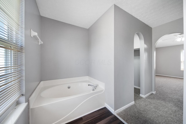 full bath featuring baseboards and a garden tub