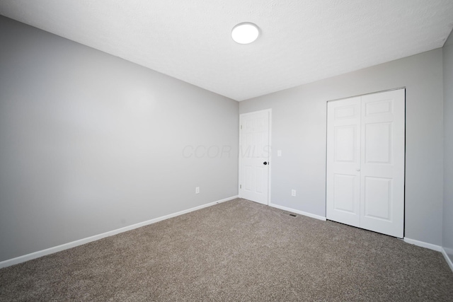 unfurnished bedroom featuring carpet floors, baseboards, and a closet