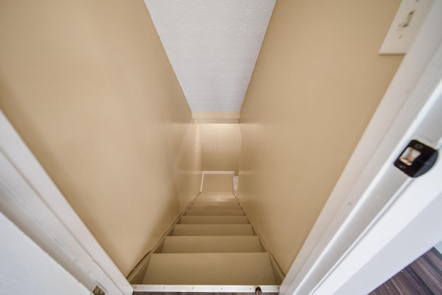 stairway featuring lofted ceiling
