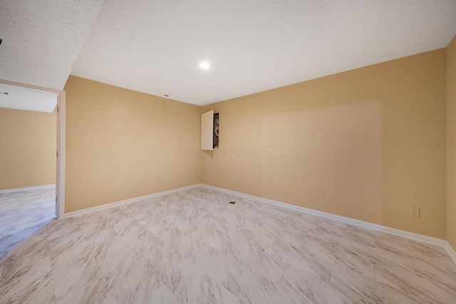 empty room featuring baseboards and recessed lighting