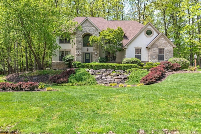 8884 Filiz Ln, Powell, OH 43065 - view of front of house with stucco siding, stone siding, and a front yard