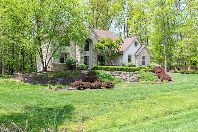 8884 Filiz Ln, Powell, OH 43065 - view of front of house featuring stucco siding, stone siding, and a front lawn