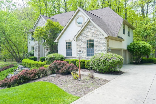8884 Filiz Ln, Powell, OH 43065 - view of front of home featuring stone siding, stucco siding, driveway, and a shingled roof