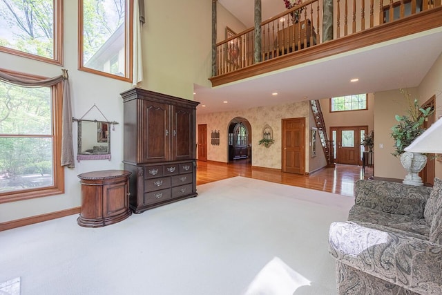 8884 Filiz Ln, Powell, OH 43065 - carpeted living room featuring a high ceiling, arched walkways, baseboards, and recessed lighting