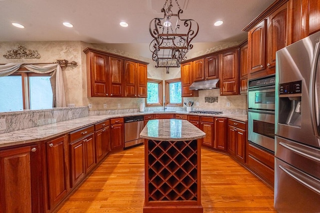8884 Filiz Ln, Powell, OH 43065 - kitchen featuring stainless steel appliances, a sink, light wood finished floors, a center island, and a chandelier