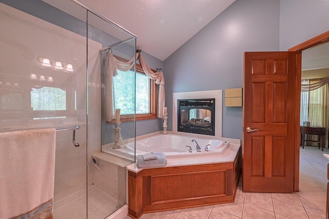 8884 Filiz Ln, Powell, OH 43065 - full bathroom featuring lofted ceiling, a garden tub, tile patterned floors, a stall shower, and a multi sided fireplace