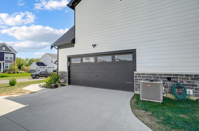 3781 Aviary Loop, Hilliard, OH 43026 - view of property exterior with stone siding, concrete driveway, central AC unit, and a garage